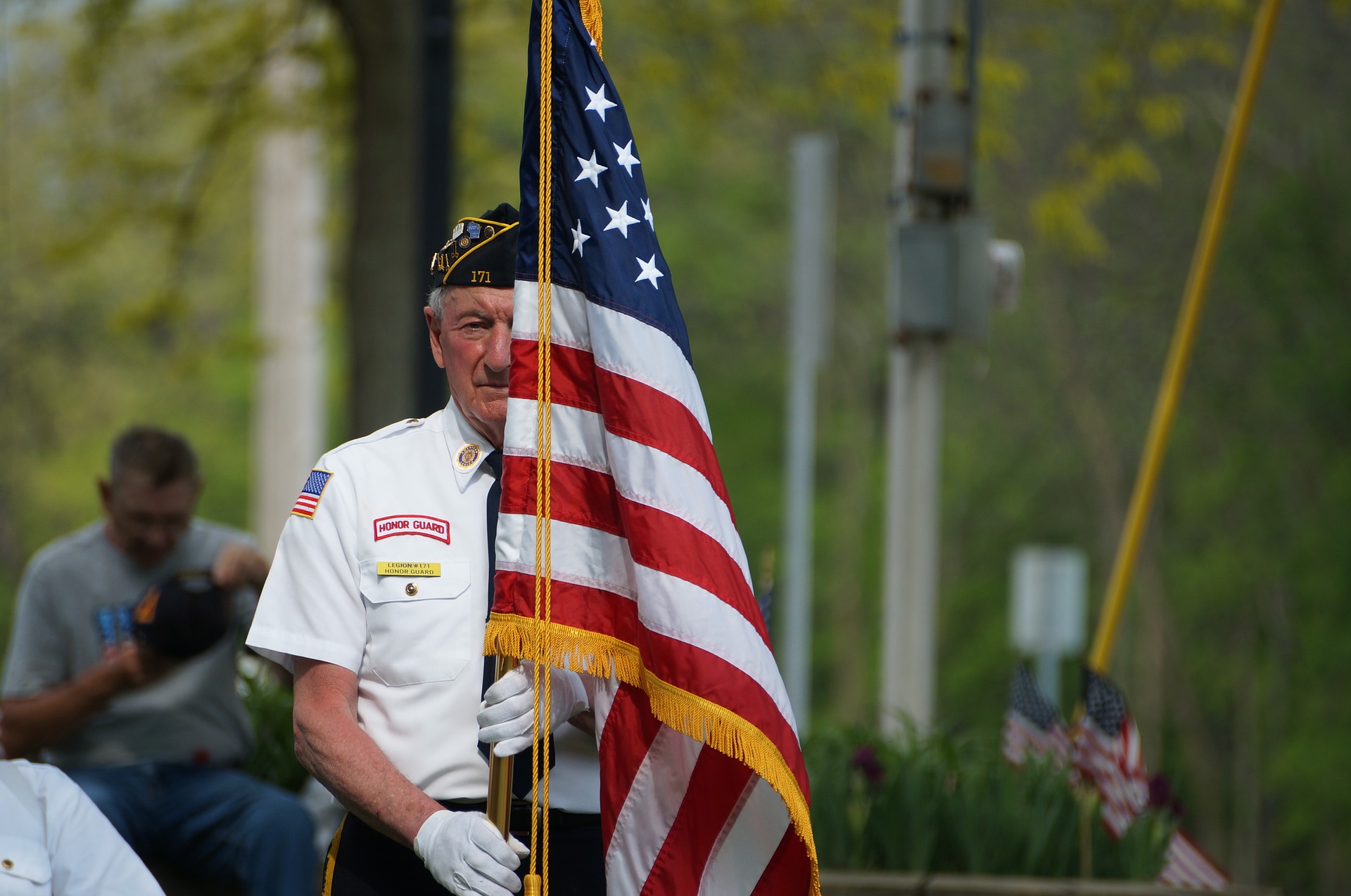 A veteran holding an American flag at a public event.