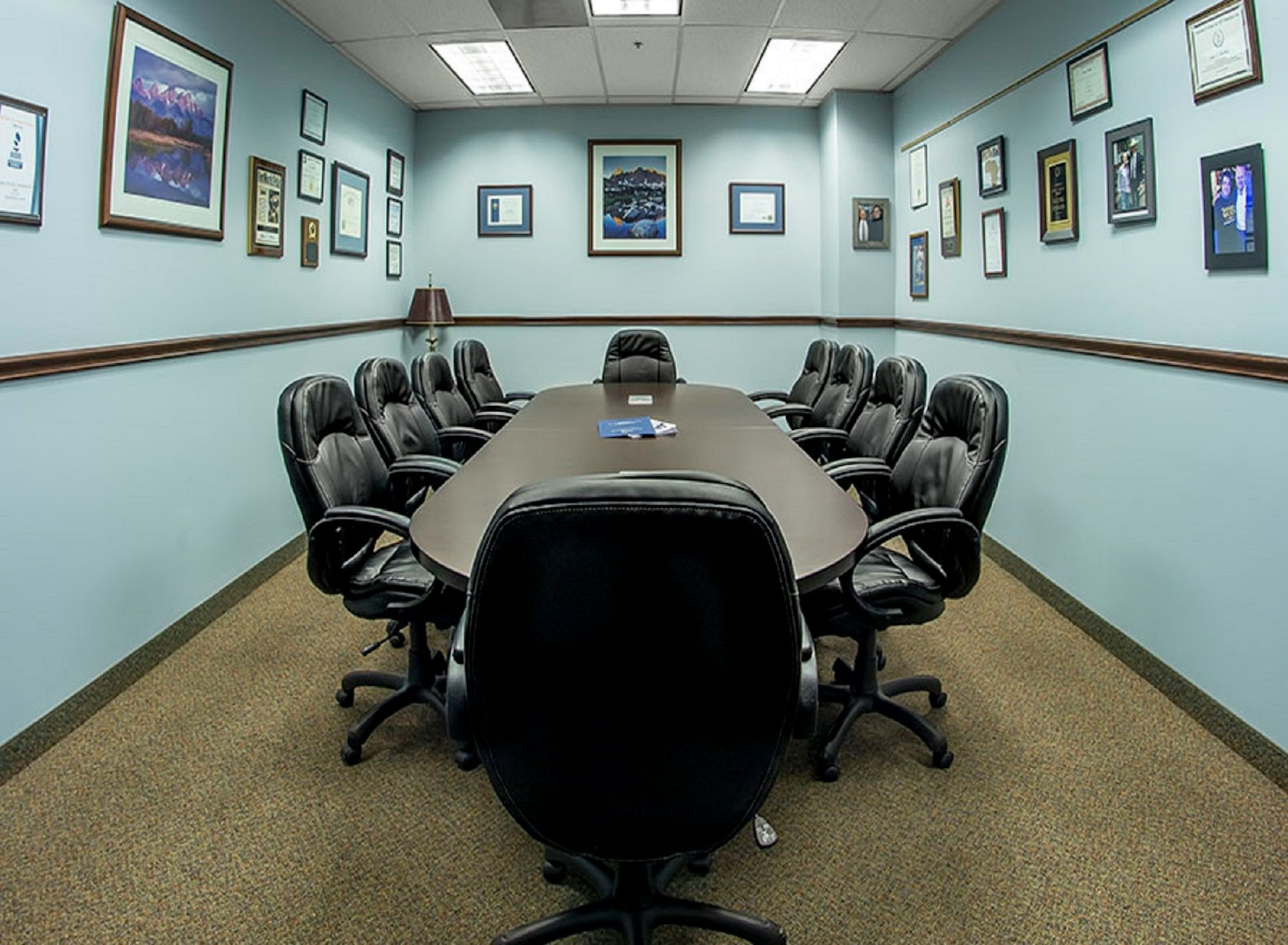 Empty black office chairs positioned around conference table